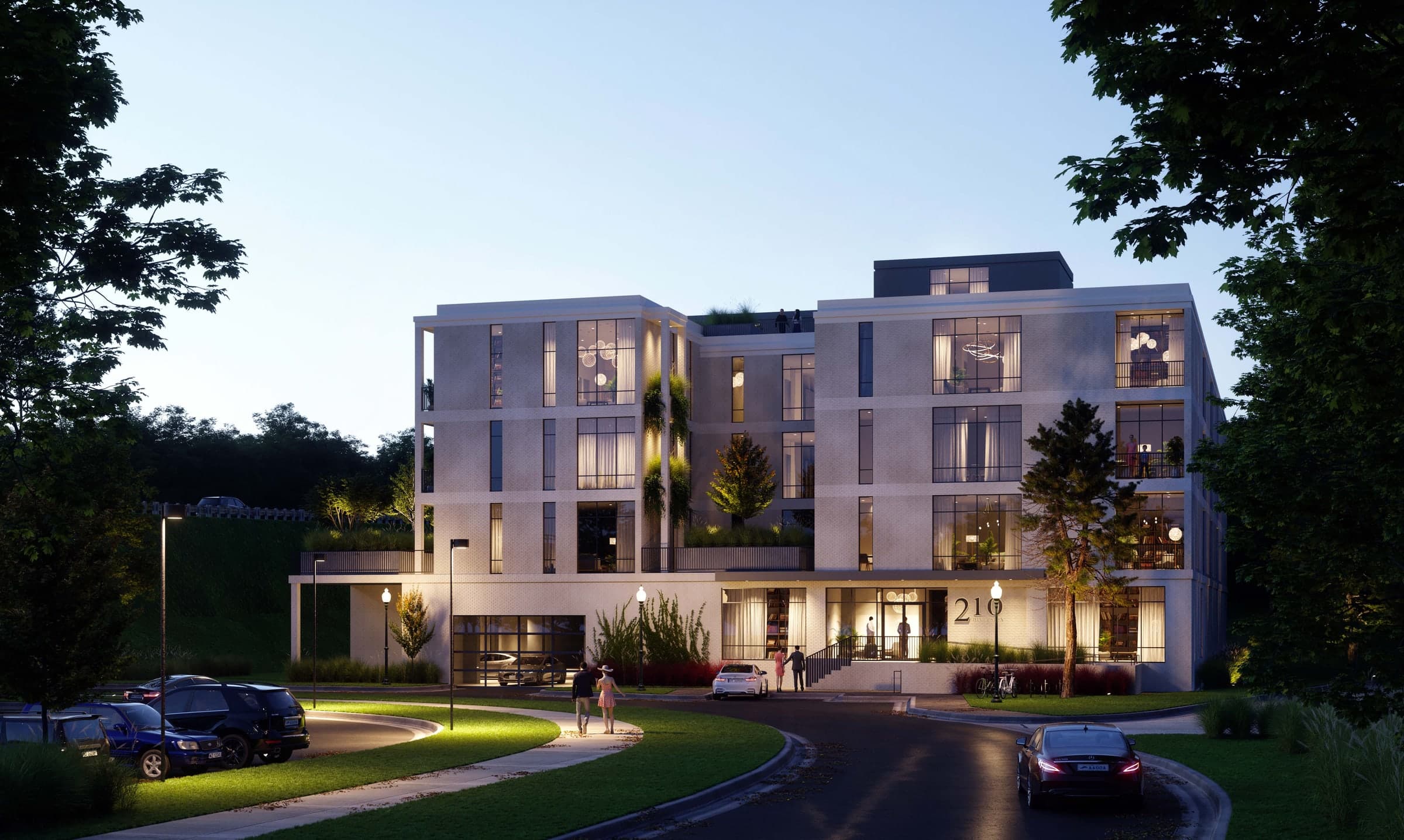Entry approach to 210 Diversion at dusk, with landscaped drive, lit lobby entry, and tucked-under parking