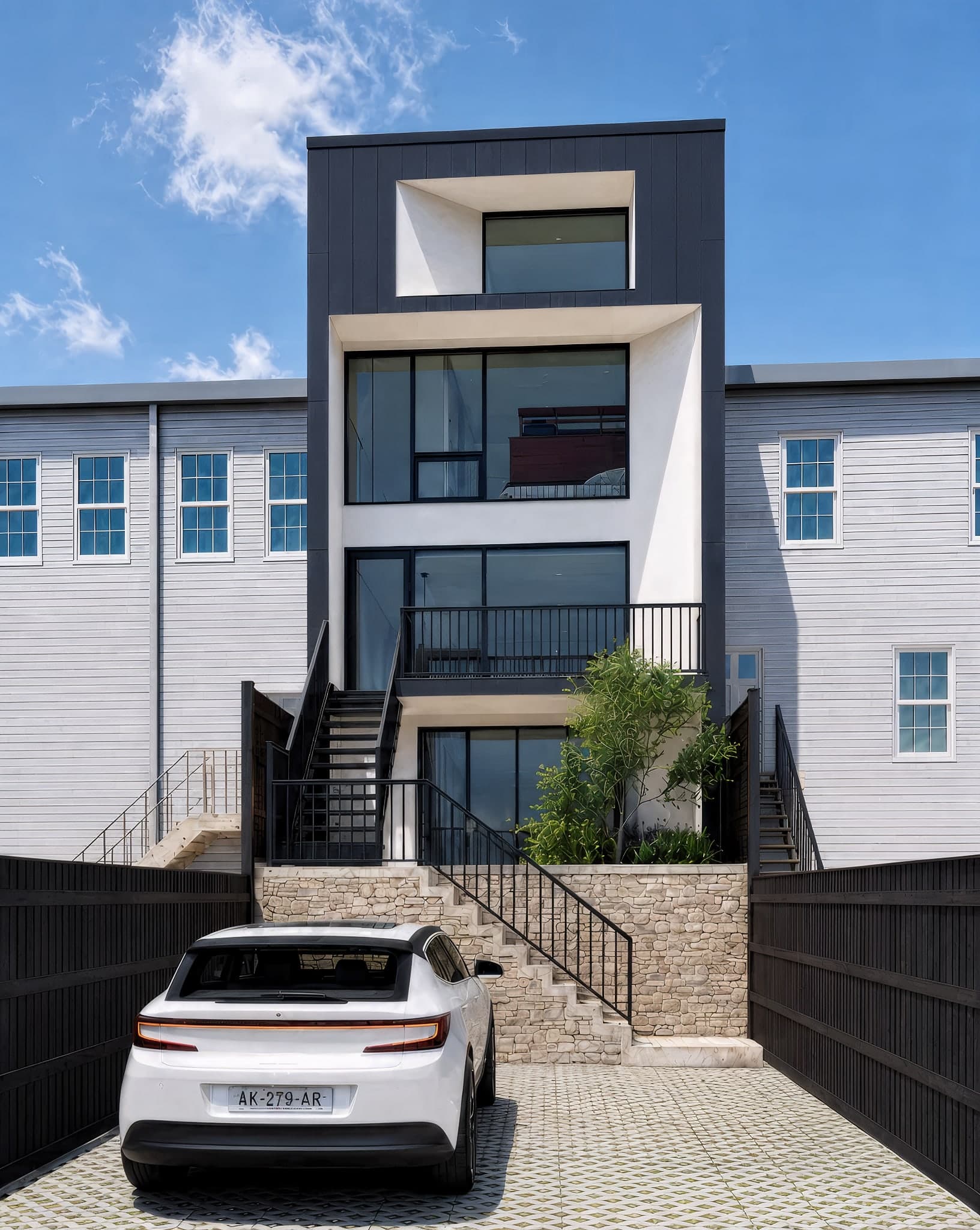 Full daytime rear elevation of the Washington DC row house, showing the stacked glass volumes from the roofline down to the stone-terraced parking court