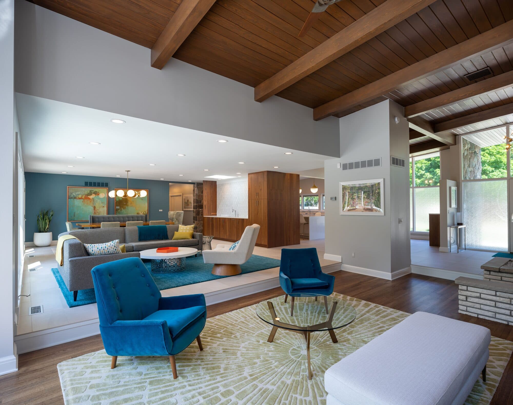 Mid-century living room with teal accent wall, exposed beams, and period-correct furnishings