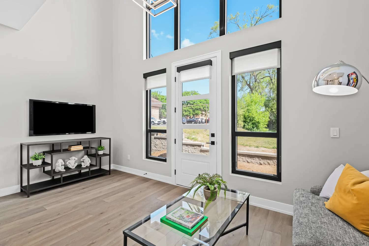 Living room with vaulted ceiling and natural light flooding through large windows